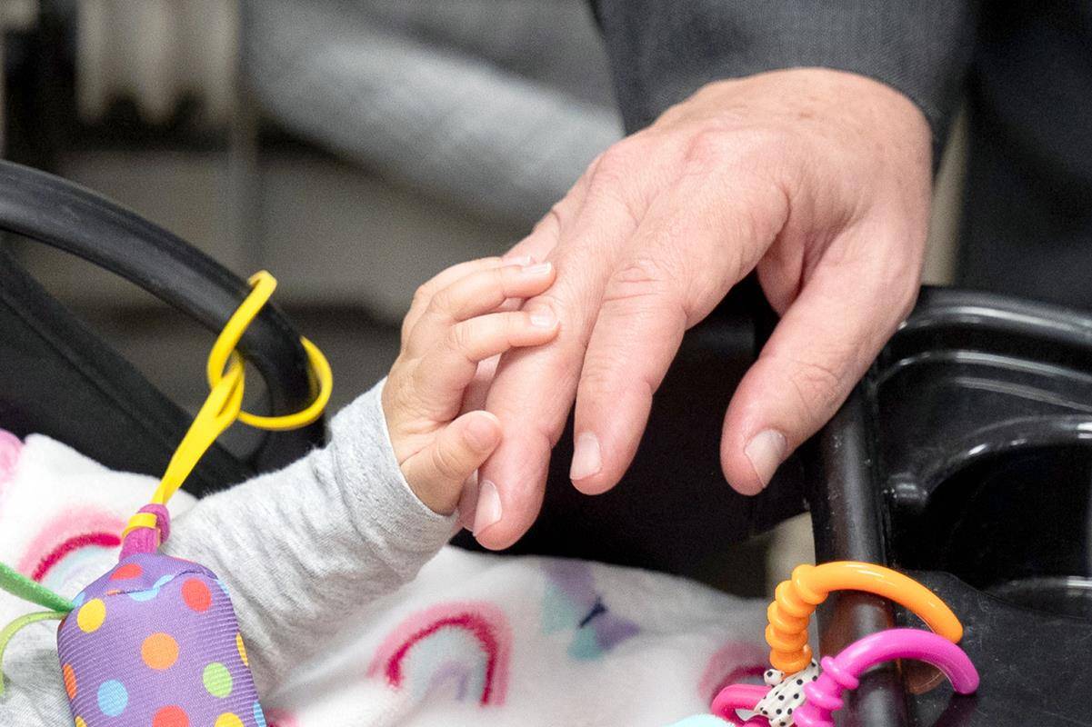 Charlotte Bishop-Elect Michael Martin, OFM Conv., greets Holy Angels' youngest resident during an April 9 visit. Belmont-based Holy Angels cares for children and adults with intellectual developmental disabilities and delicate medical conditions.
