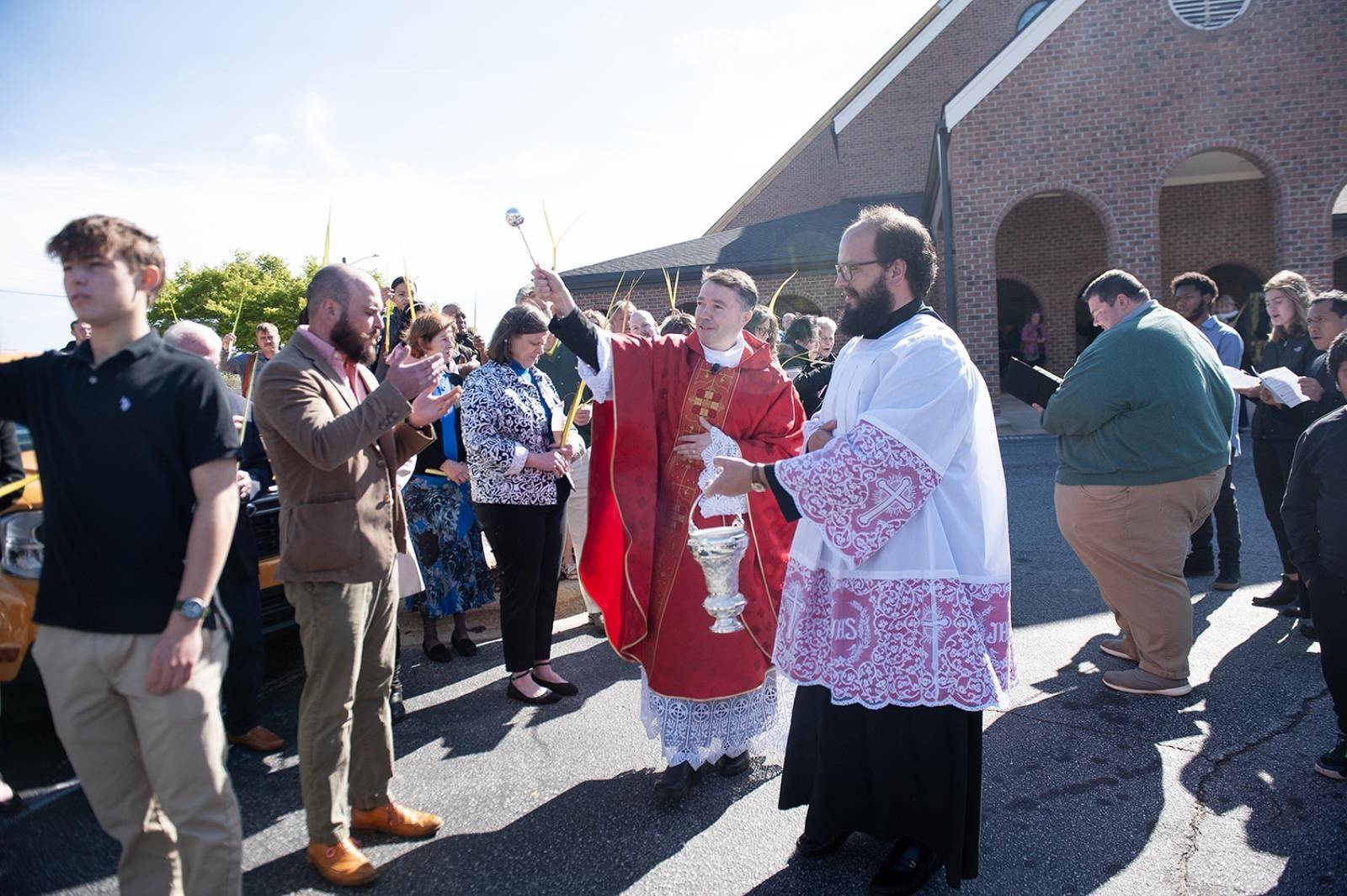 Immaculate Conception Parish in Hendersonville started Holy Week by holding palms in the air as Fathers Andres Felipe Gutierrez and David O'Connor blessed them. (Photos provided)