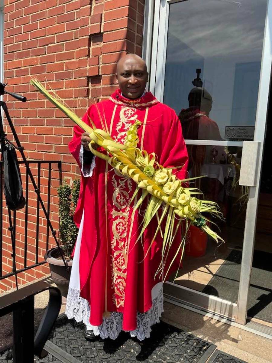 Father Melchesideck Yumo holds a palm at St. Benedict the Moor Church in Winston-Salem. (Provided photo)