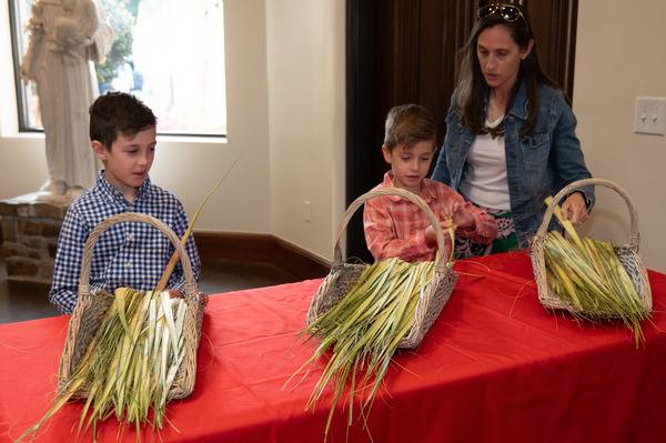 St. Pius X parishioners select palms on their way into Mass. (Mary Ann Luedtke)