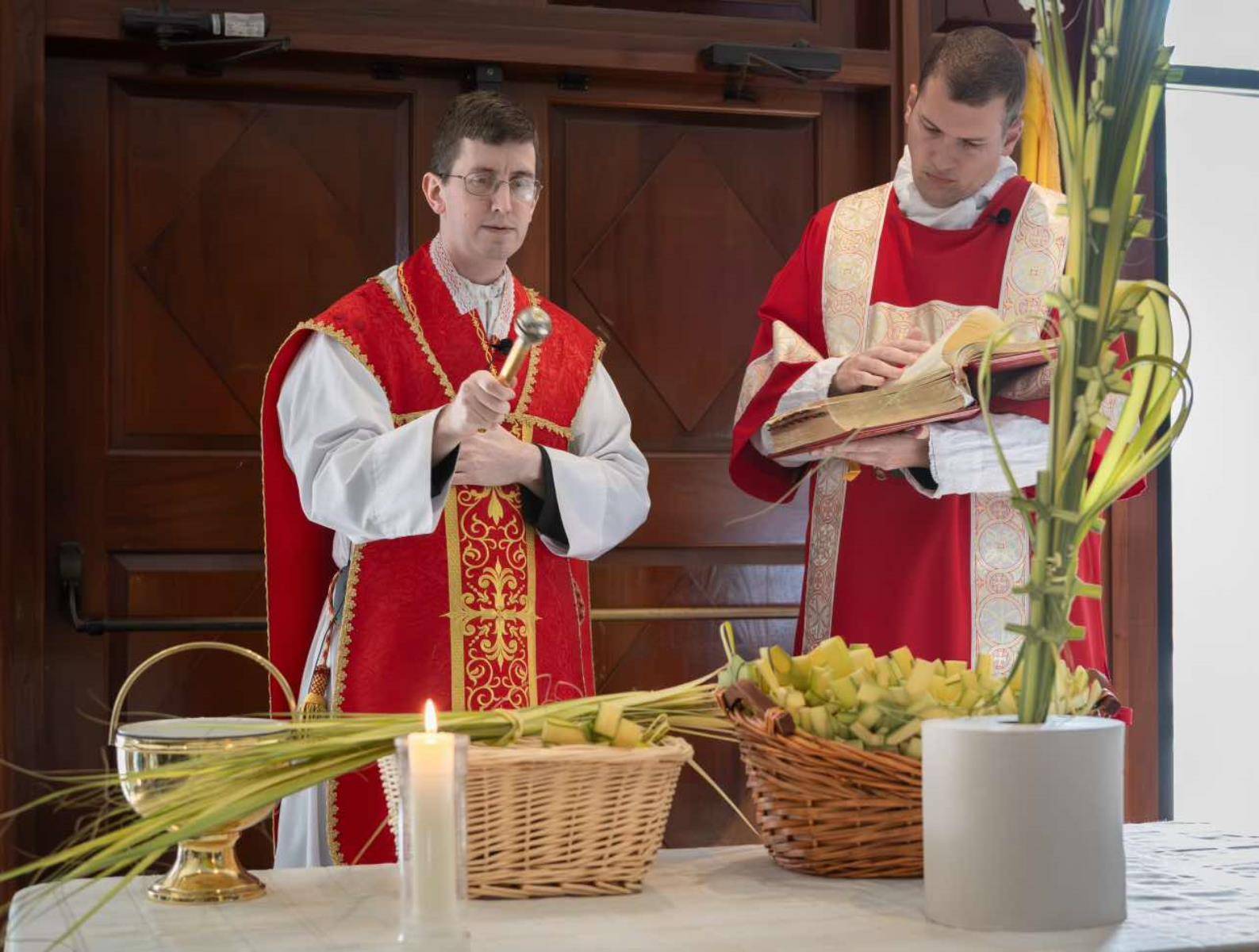 Father Matthew Codd and Deacon Christopher Angermeyer bless the palms for the Vigil Mass at St. Thomas Aquinas Church in Charlotte. (Edward Chaplinsky Jr.)